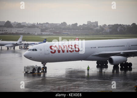 Boston Massachusetts New England North America USA , Logan International Airport  a Swiss airplane pushing back in the rain Terminal E Stock Photo