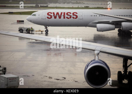 Boston Massachusetts New England North America USA , Logan International Airport  a Swiss airplane pushing back in the rain Terminal E Stock Photo