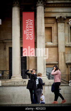 Tourist photographer outside The National Gallery  City of Westminster in London the capital city of England