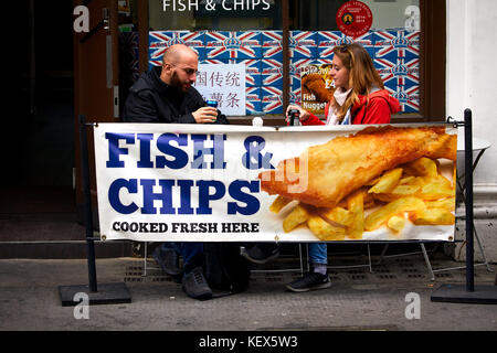 Couple eating Fish and Chips on  Museum Street in London the capital city of England Stock Photo
