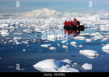 Members of an expedition cruise to Antarctica in a Zodiak in Fournier Bay in the Gerlache Strait on the Antarctic peninsula. The Antarctic peninsula is one of the most rapidly warming areas on the planet. Stock Photo