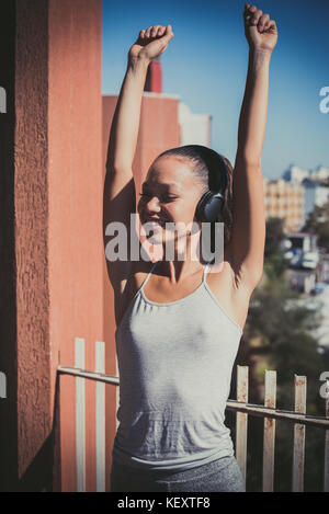 Young asian teen woman outdoor portrait closed eyes sunlight smiling with headphones portrait Stock Photo