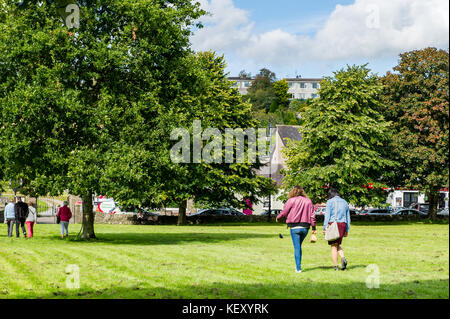 Blarney Square on a sunny day with people walking, grass, trees and copy space. Blarney, County Cork, Ireland. Stock Photo