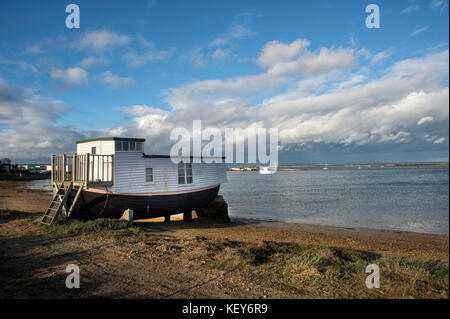 Houseboat on the shore of Kench Cove, Hayling Island, Langstone Harbour, Hampshire, UK. Stock Photo