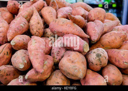 Close up fresh sweet potato with root at farmer market as a food background. Organic, healthy, vegetarian diet food concept. Selective focus. Stock Photo
