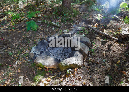 Unattended campfire at a campsite along the Carrigain Notch Trail near EB&L Railroad’s Camp 20 in the Pemigewasset Wilderness, New Hampshire. Stock Photo