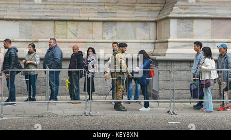 Italian soldier inspects tourists before they enter Milan, Italy's Duomo Cathedral Stock Photo