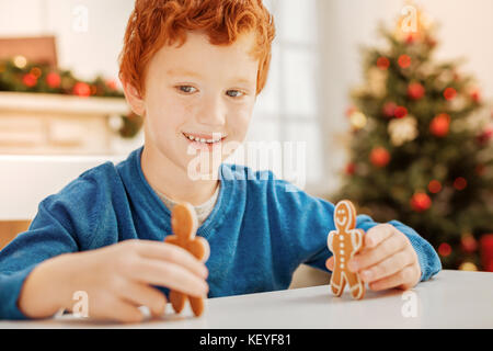 Adorable child smiling while playing with homemade cookies Stock Photo