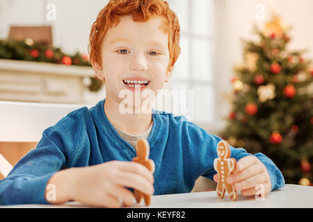 Extremely happy boy having fun and playing during breakfast Stock Photo