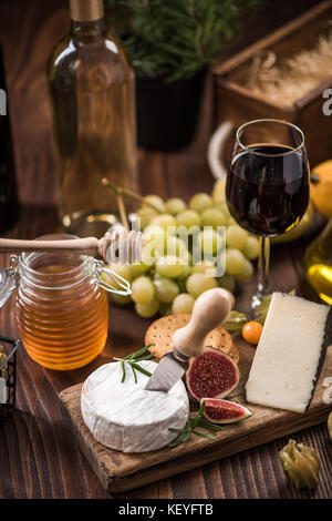Cheese board with crackers,fig and grapes and honey. Stock Photo
