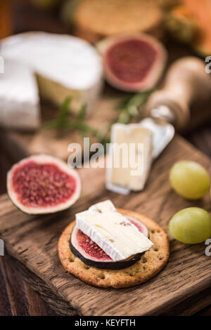 Cheese crackers with camembert and fresh fig. Stock Photo