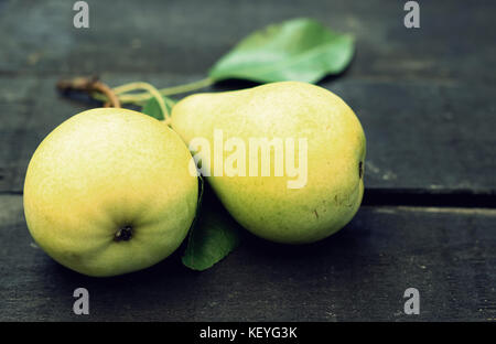 Two yellow pears on a dark wooden background Stock Photo