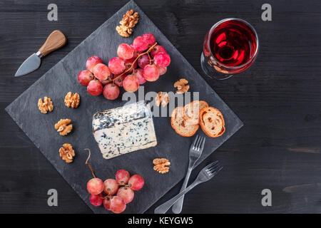 Blue cheese and grapes on black with copy space Stock Photo
