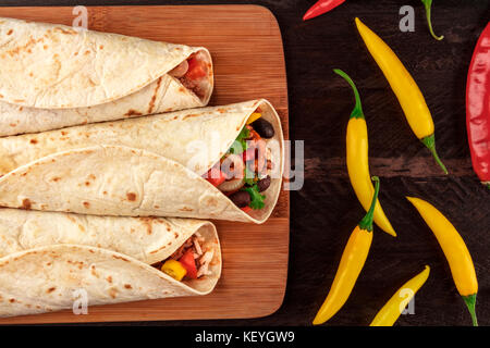 Mexican burritos with chili peppers on dark textures Stock Photo