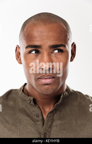 Vertical close up image of pensive thoughtful man looking away over white background Stock Photo
