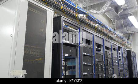 Many powerful servers running in the data center server room. Many servers in a data center. Many racks with servers located in the server room. Bright display a plurality of operating equipment. Stock Photo