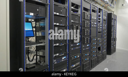 Many powerful servers running in the data center server room. Many servers in a data center. Many racks with servers located in the server room. Bright display a plurality of operating equipment. Stock Photo
