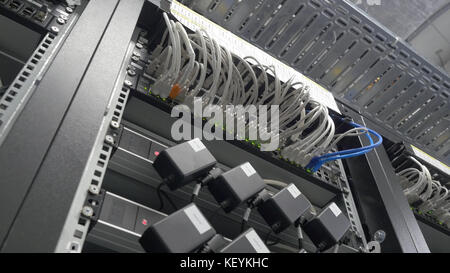 Storage servers are located in the server room of the data center. Back of the server installed in the server room. Many cables are connected to a powerful computers Stock Photo