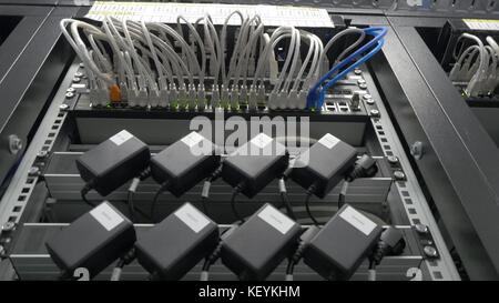 Storage servers are located in the server room of the data center. Back of the server installed in the server room. Many cables are connected to a powerful computers Stock Photo