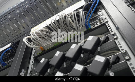 Storage servers are located in the server room of the data center. Back of the server installed in the server room. Many cables are connected to a powerful computers Stock Photo