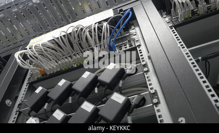 Storage servers are located in the server room of the data center. Back of the server installed in the server room. Many cables are connected to a powerful computers Stock Photo