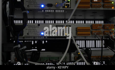 Back of the server installed in the server room. Many cables are connected to a powerful computers. Front panel of the central router. Optical links of a powerful Internet server. Connection of optical Stock Photo