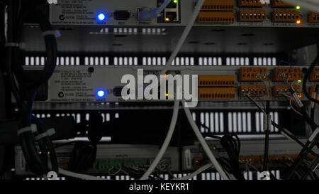 Back of the server installed in the server room. Many cables are connected to a powerful computers. Front panel of the central router. Optical links of a powerful Internet server. Connection of optical Stock Photo