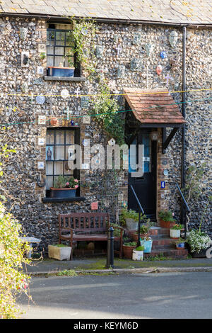 A small pretty flint cottage with small porch and plants on the steps behing Holy Trinity Church, Broadstairs, Kent, UK Stock Photo