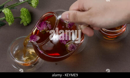 Chinese tea ceremony is performed by tea master. Chinese tea ceremony. Female hands pouring tea into cups Stock Photo