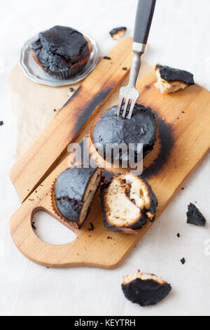 burned muffins - black cupcakes, failed baking, catastrophe in the kitchen, burned on charcoal Stock Photo