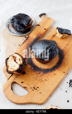 burned muffins - black cupcakes, failed baking, catastrophe in the kitchen, burned on charcoal Stock Photo