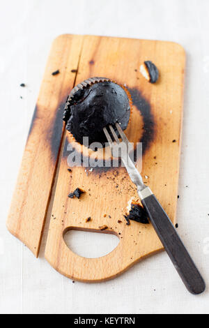 burned muffins - black cupcakes, failed baking, catastrophe in the kitchen, burned on charcoal Stock Photo