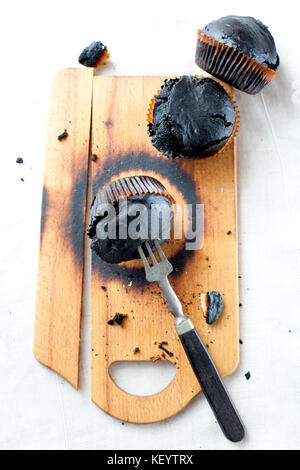 burned muffins - black cupcakes, failed baking, catastrophe in the kitchen, burned on charcoal Stock Photo