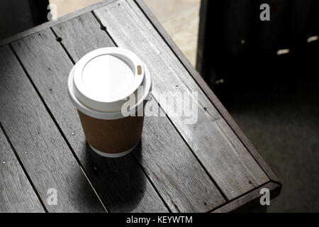 hot coffee in takeaway cup on wooden table Stock Photo