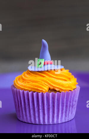 Halloween cupcake with a witch's hat on orange cream Stock Photo