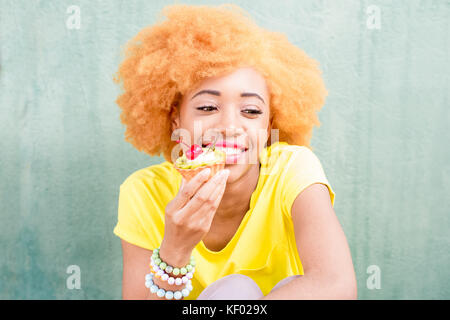 Colorful portrait of an african woman with sweet dessert Stock Photo
