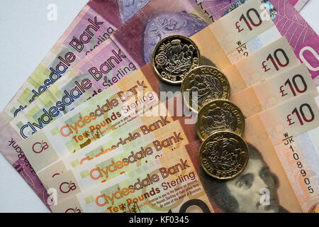 Clydesdale Bank Scottish twenty £20, plastic polymer ten £10 banknotes with Robert Burns and hexagonal one pound £1 coins on plain white background Stock Photo