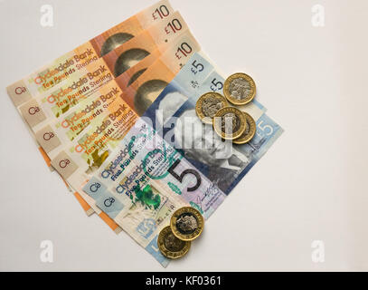 New plastic polymer Clydesdale Bank Scottish ten £10, five pounds £5 banknotes and new hexagonal one pound £1 coins, on a plain white background Stock Photo