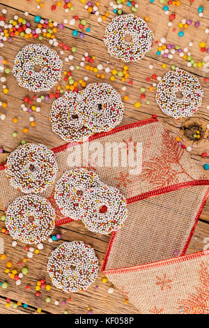 Colored chocolate rings with Christmas decoration on wood table Stock Photo