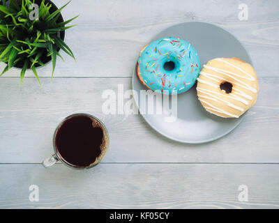 donuts and coffee on gray wooden background, copy space, top view Stock Photo