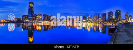 Melbourne docklands suburb with modern high-rise towers at sunset relecting in Yarra river. Stock Photo