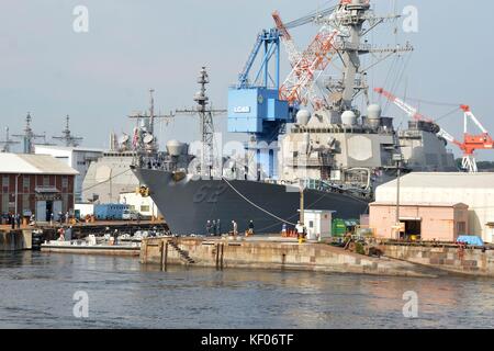 The U.S. Navy Arleigh Burke-class guided-missile destroyer USS Fitzgerald leaves the dry dock at Fleet Activities Yokosuka to undergo further repairs following its collision with a container ship October 8, 2017 in Yokosuka, Japan. Stock Photo