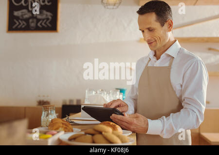 Joyful smart cook using a tablet Stock Photo