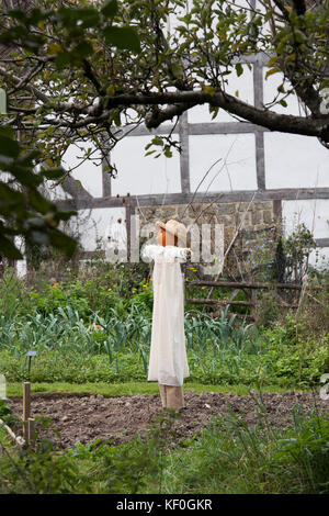 Old fashioned pumpkin head scarecrow in front of a medieval timber framed house at Weald and Downland museum, autumn show, Singleton, Sussex, England Stock Photo