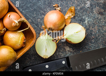 Halved onion bulbs on old kitchen table. Stock Photo