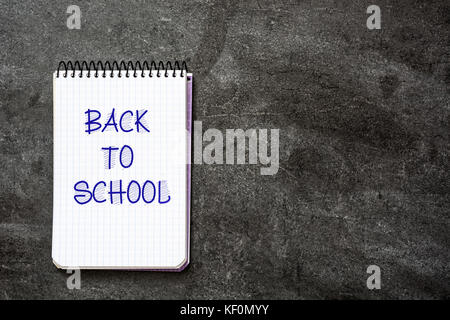 "Back to school" message written in a notebook on slate background. Copyspace. Stock Photo