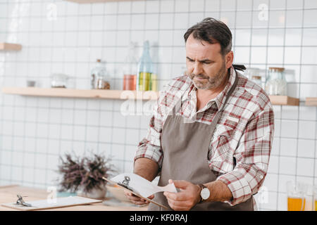 bartender checking paper on clipboard Stock Photo