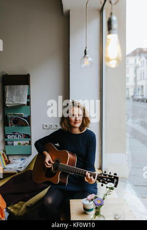 blonde female singer playing a song Stock Photo