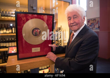 Stuttgart, Germany. 24th Oct, 2017. Choir director Gotthilf Fischer holding a golden record in his hands in Stuttgart, Germany, 24 October 2017. For 7 decades Gotthilf Fischer has been bringing choir music to Germany's turntables. His music label awarded the composer and director of the Fischer Choir with a golden record for '70 years of recording'. Credit: Marijan Murat/dpa/Alamy Live News Stock Photo