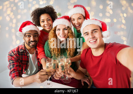 happy friends celebrating christmas at office party Stock Photo